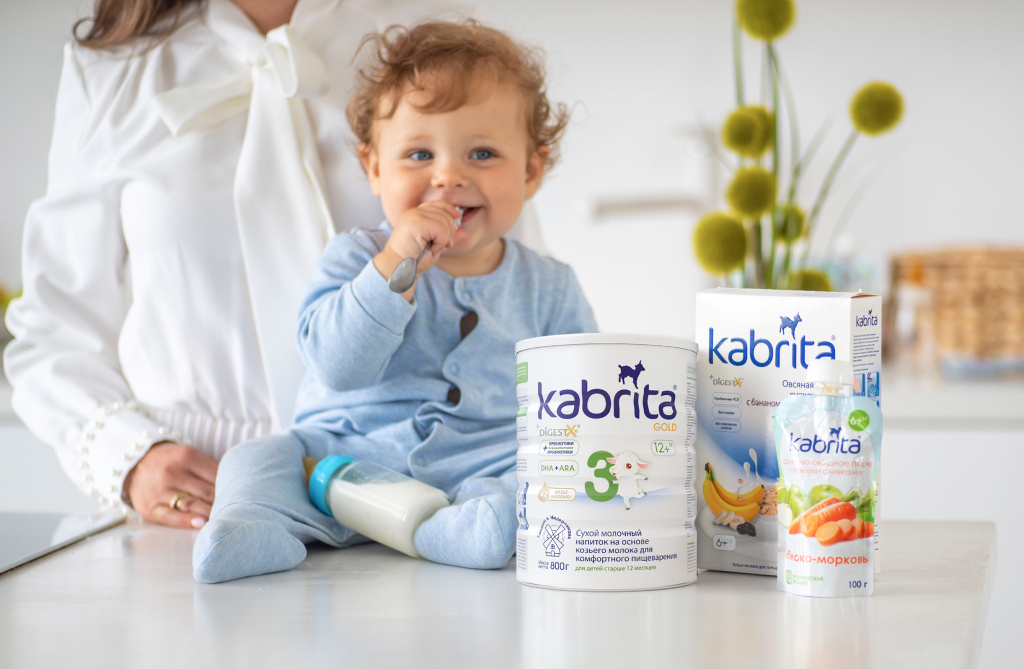 Малыш рядом с детским питанием Kabrita и мамой