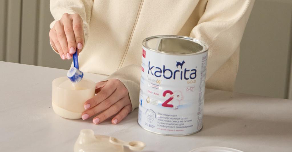 Мама насыпает детскую молочную смесь Kabrita мерной ложкой