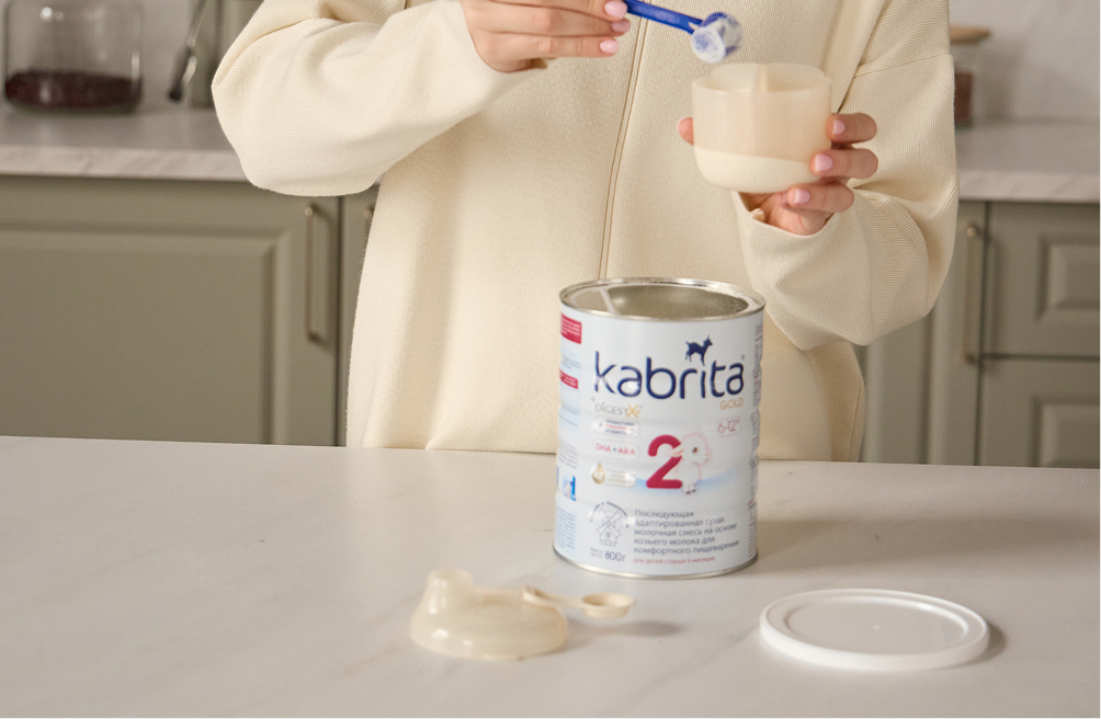 Банка Kabrita Gold 2 с липидным комплексом DigestX®, пробиотиками и DHA+ARA рядом с декоративной фигуркой козочки — последующая смесь на основе козьего молока для детей старше 6 месяцев, произведена в Нидерландах